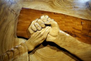 Jesus hand on cross tolding man's hand.